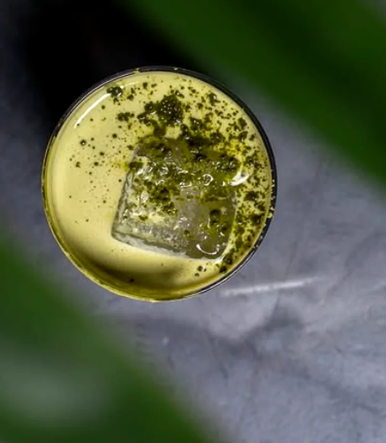 Overhead view of a matcha cocktail with a clear ice cube