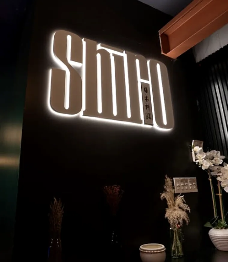 The illuminated SHIRO wordmark on the dining room wall