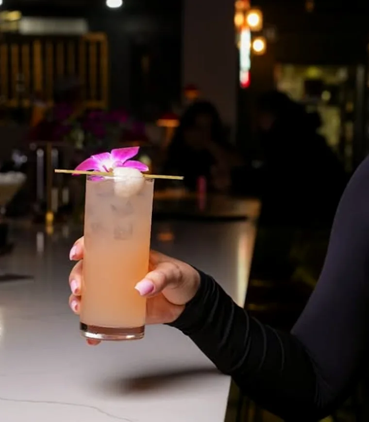 An orchid-garnished highball held in the dining room