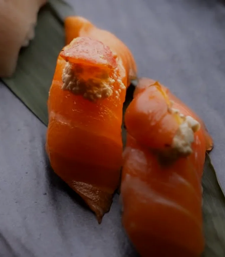 Close-up of two pieces of salmon nigiri on a slate board