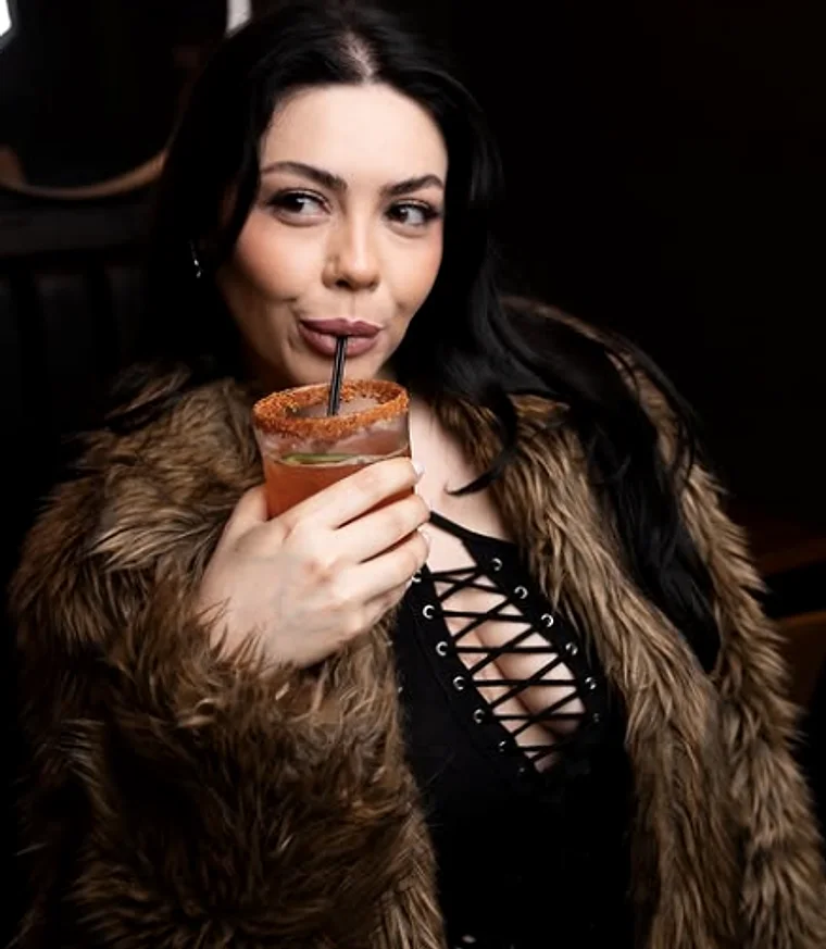 A guest with a chilli-rimmed house cocktail in the dining room